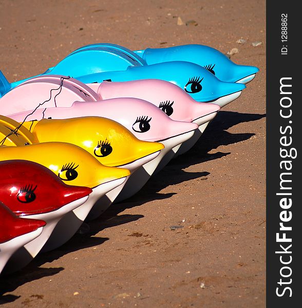 A row of plastic boats in the form of dolphins. A row of plastic boats in the form of dolphins