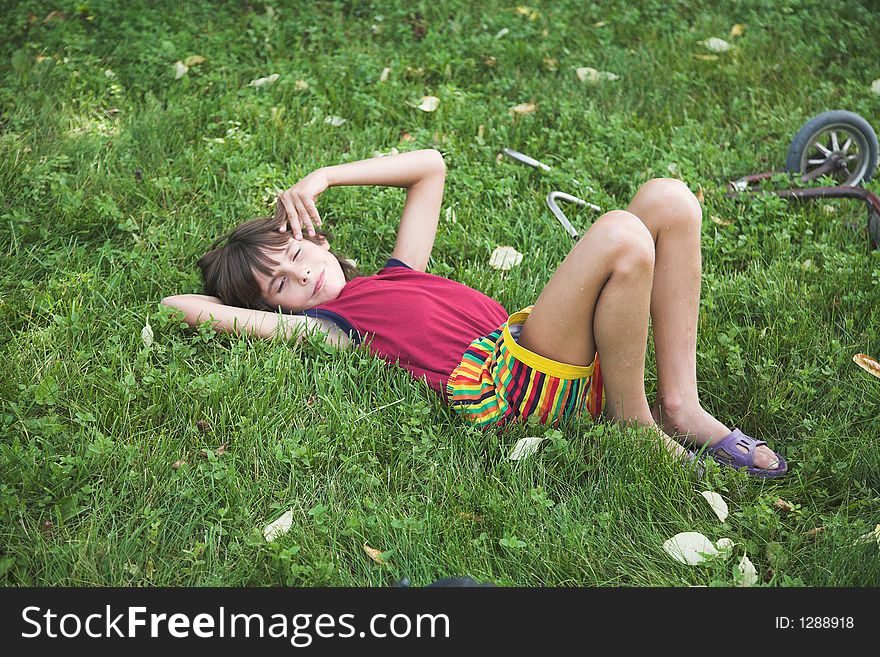 Boy rests upon grass by summer. Boy rests upon grass by summer