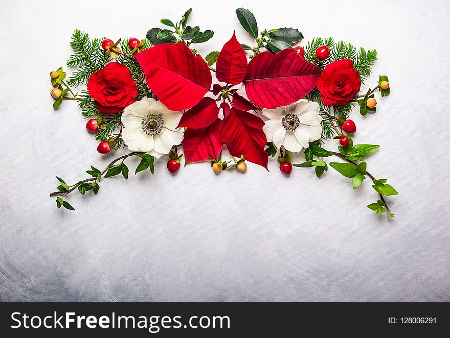 Christmas decoration with poinsettia, holly, ivy, mistletoe and fir branches on light background