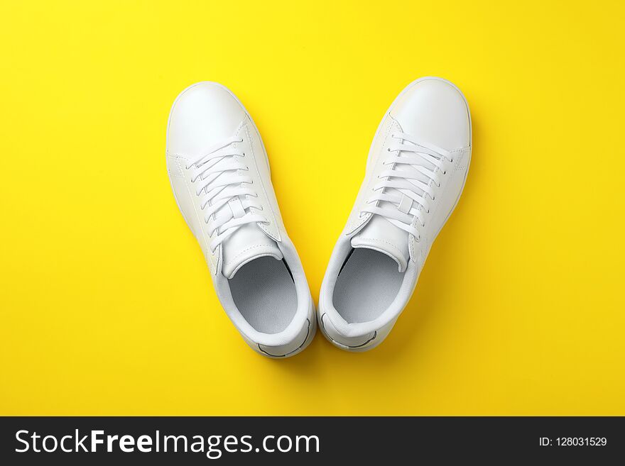 Pair of sneakers on color background