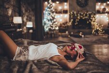 Beautiful Asian Woman Is Lying In Bed And Wearing Sleeping Mask At Home Near Christmas Tree In Cozy Interior. Interior Royalty Free Stock Photo