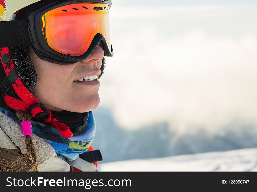 Portrait of a snowboarder woman freerider in helmet in snowy mountains.