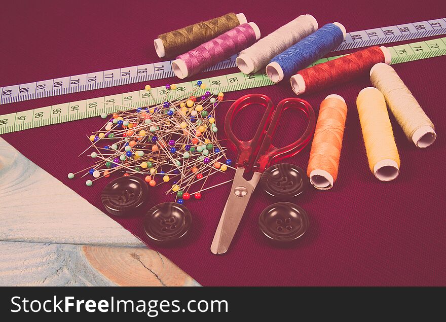Supplies and accessories for sewing - scissors, threads, pins, buttons, centimeter.