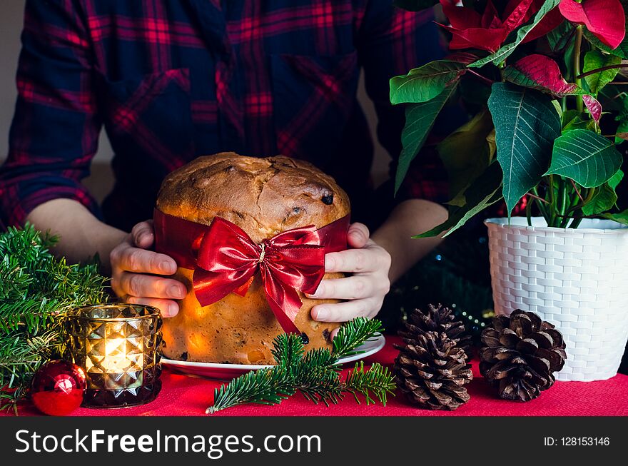 Woman holding Panettone traditional Italian cake for Christmas with raisins and candied orange.