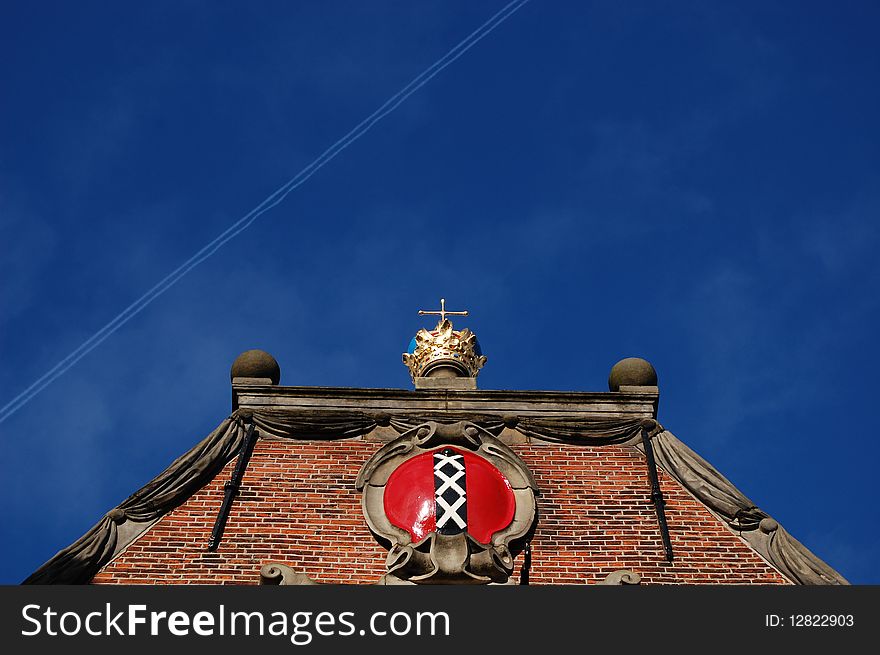 Monumental roof in Amsterdam with a golden crown on top of the building. Monumental roof in Amsterdam with a golden crown on top of the building