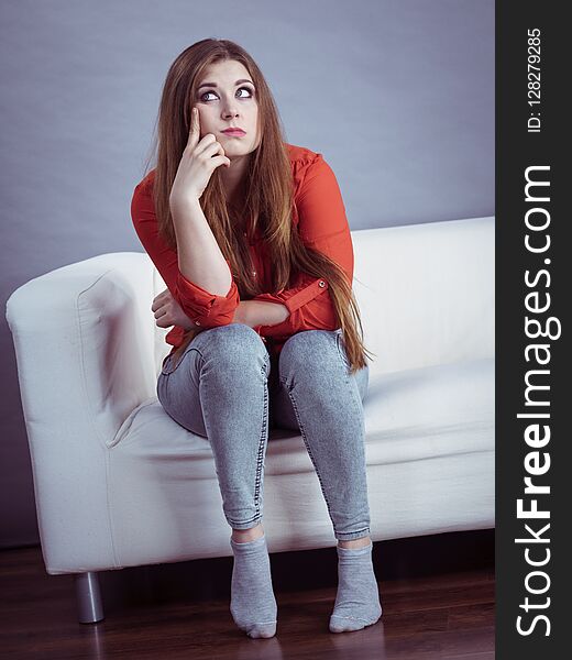 Angry, off young woman. Attractive female with long brown hair sitting on sofa being mad and irritated having displeased face expression. Angry, off young woman. Attractive female with long brown hair sitting on sofa being mad and irritated having displeased face expression.