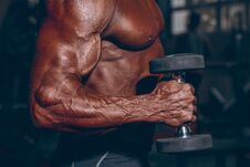 Man In Gym. Muscular Bodybuilder Guy Doing Exercises With Dumbbell. Strong Person With Tense Male Hand With Veins Stock Photo Man In Gym. Muscular Bodybuilder Guy Doing Exercises With Dumbbell. Strong Person With Tense Male Hand With Veins Stock Photo