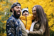 Father, Mother And Daughter Shows Tongue. Autumn Walk In The Park Royalty Free Stock Photo