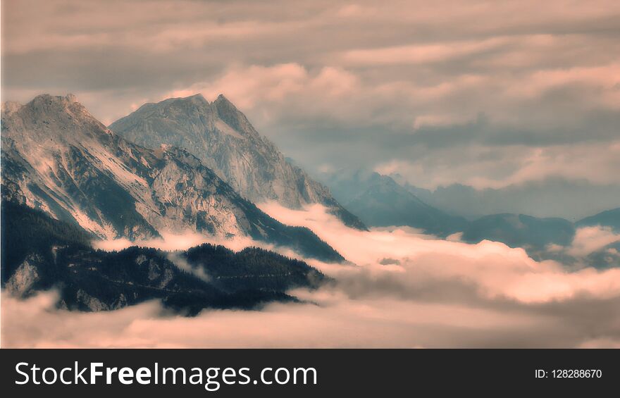 High mountain peaks rising from the fog in the valley, view to valley,high altitude scenic mountain landscape, steep rocks. Relaxing nature, bad weather,clouds, mist.Alps,Austria .