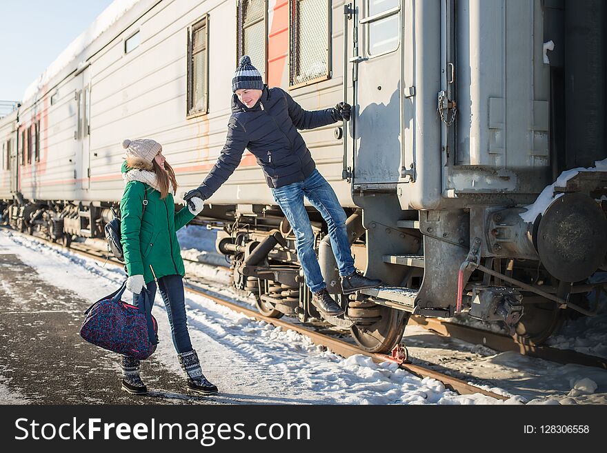 Couple at railway station near train in a winter time