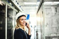 A Portrait Of An Industrial Woman Engineer On The Phone, Standing In A Factory. Stock Images