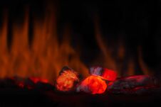 Red Hot Coal Nugget In Focus On Dark Background With Flames. Background Of Raw Coals With Soft Focus Exclusion With Color And Temp Stock Photo