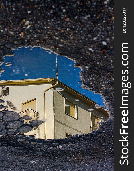 Reflection Of A House In The Puddle