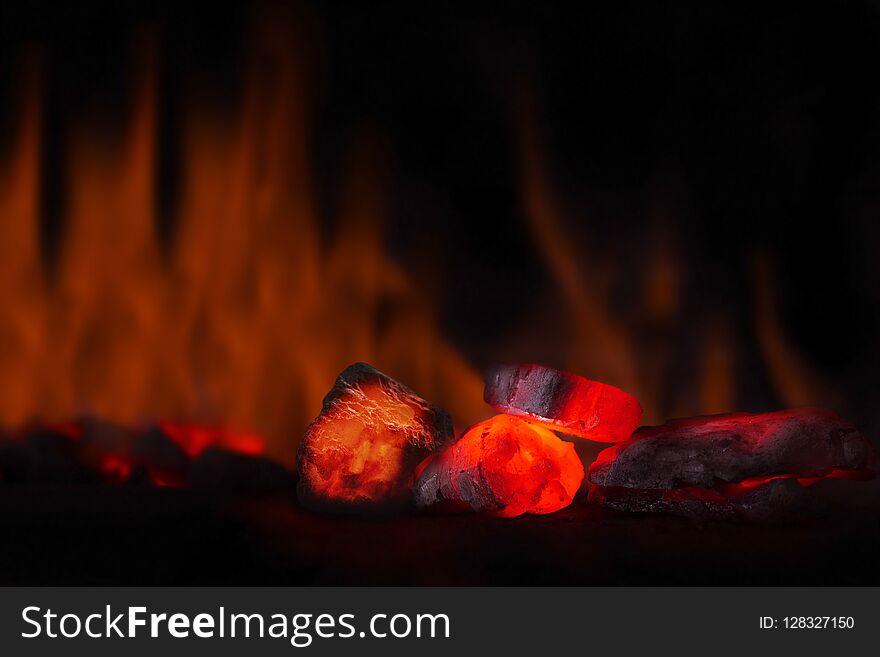 Red Hot Coal Nugget In Focus On Dark Background With Flames. Background Of Raw Coals With Soft Focus Exclusion With Color And Temp