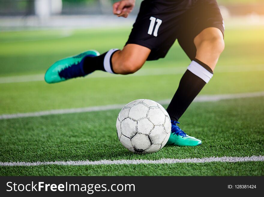 Soccer player speed run to shoot ball to goal on artificial turf. Soccer player training or football match.