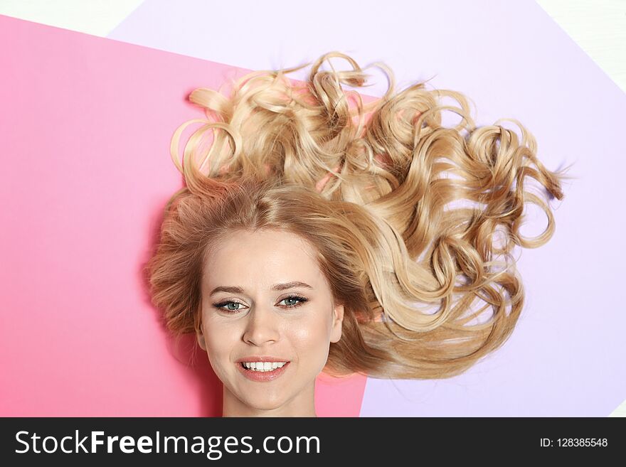 Beautiful Woman With Healthy Long Blonde Hair On Color Background