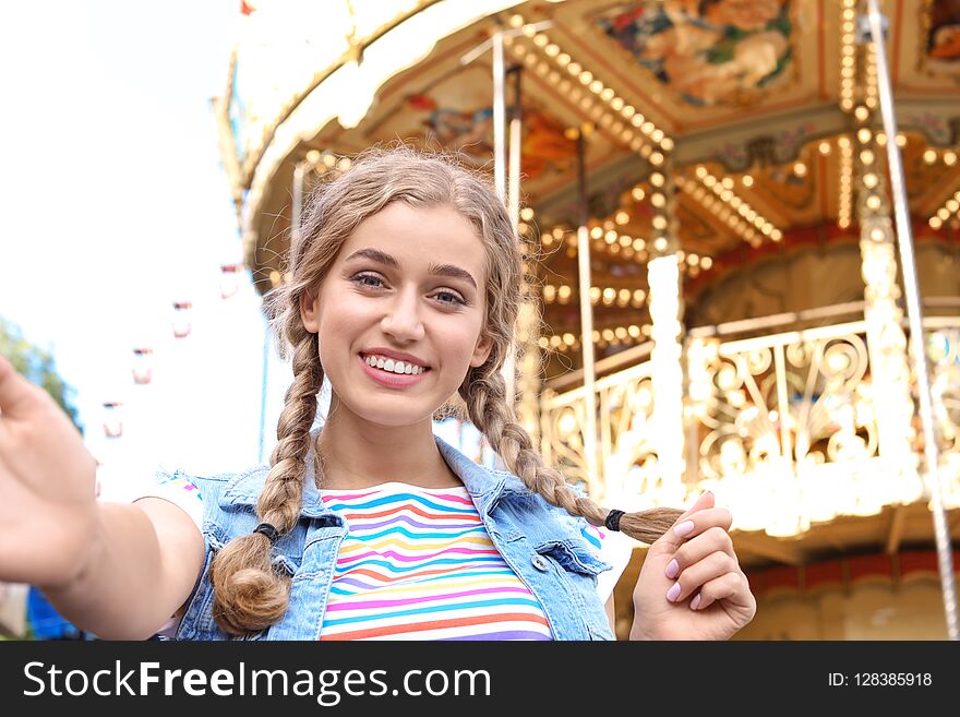 Attractive woman taking selfie in amusement park