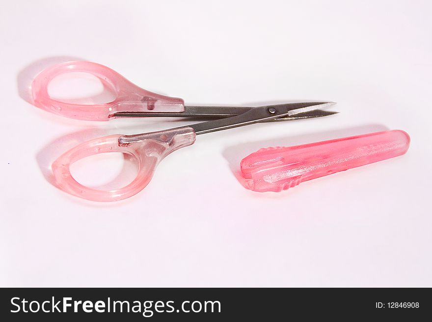 Small manicure scissors with pink cap isolated.