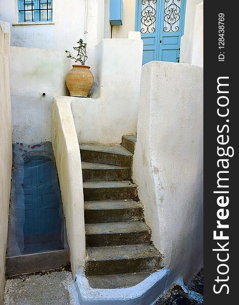 Crete architecture. White wall, blue doors and window, staircase and flower in clay pot. Greece. Crete architecture. White wall, blue doors and window, staircase and flower in clay pot. Greece