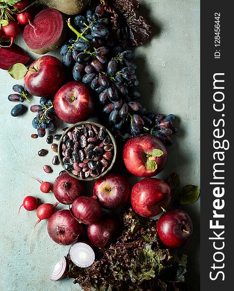 Fresh various pink, red and purple fruits and vegetables on gray marble background. Top view