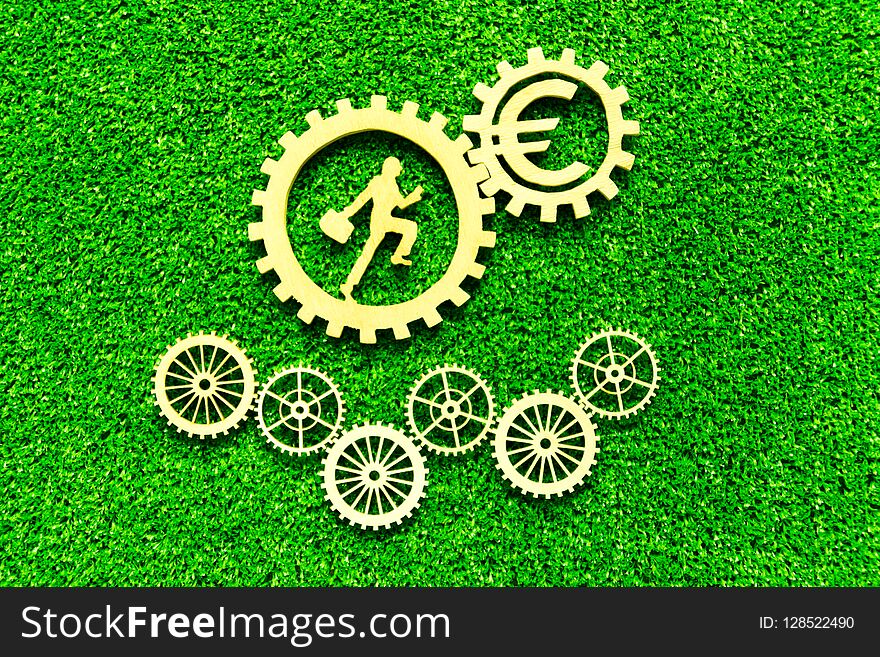 Gear, euro, man with a suitcase on the background of artificial green grass. business, finance, cash flow.