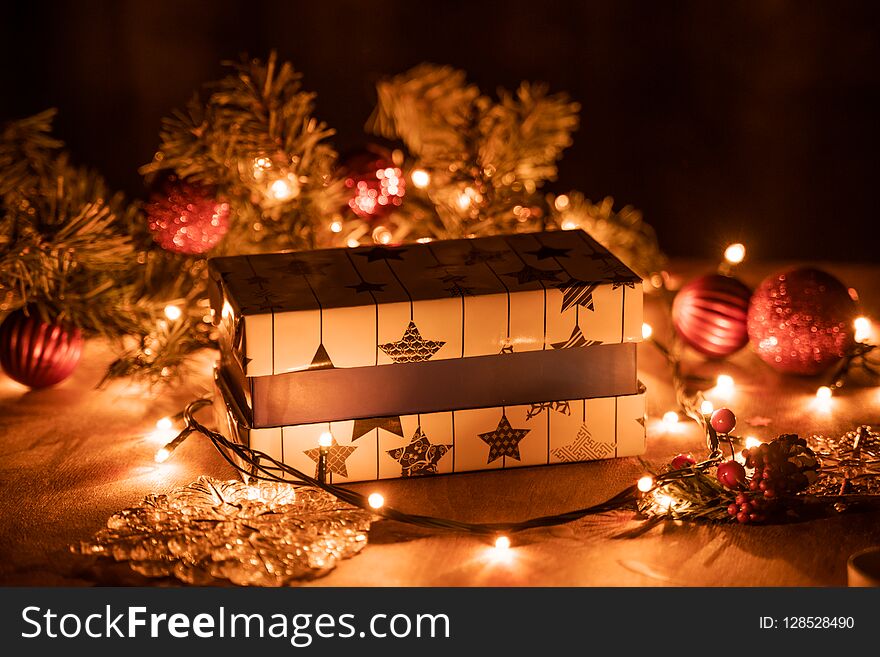 Christmas gift boxes decoration with Christmas tree and candle lights on the wooden table with bokeh lights.