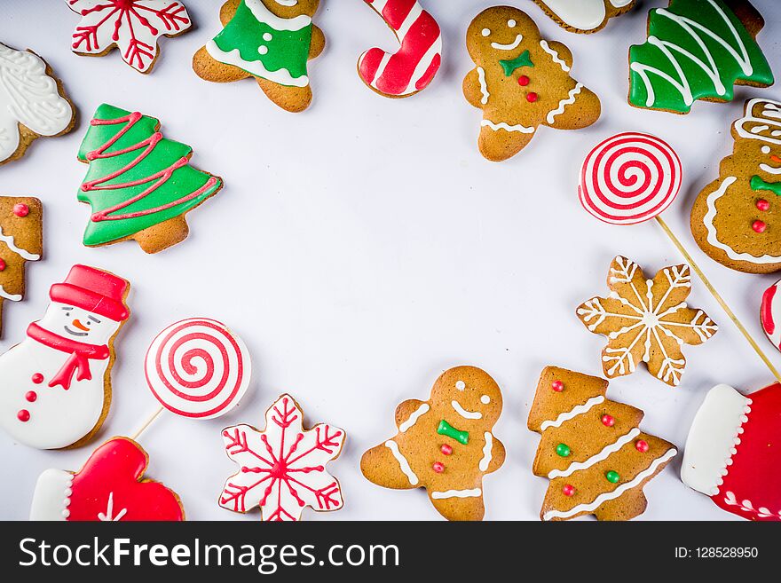 Various traditional colorful sugar glazed christmas gingerbread cookies, on white background top view copy space