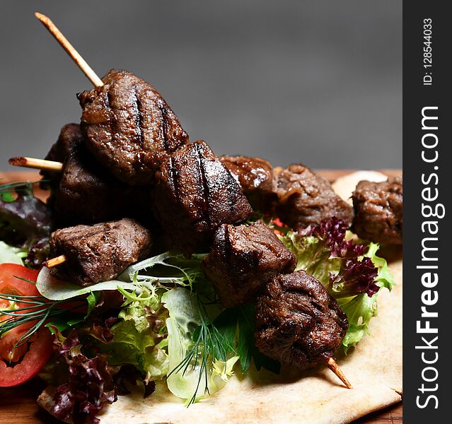 Tasty Barbecue Beef Shashlik On Wood Plate With Fresh Vegetables And Steam Smoke