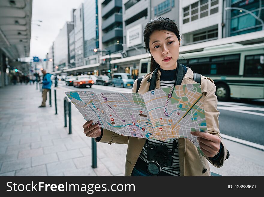 Beautiful female traveler holding the map and finding the right direction back to hotel in Japan. backpacker travel in Kyoto lifestyle. asian female model traveling. Beautiful female traveler holding the map and finding the right direction back to hotel in Japan. backpacker travel in Kyoto lifestyle. asian female model traveling.