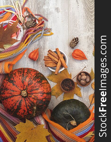 Green and orange Pumpkin, persimmons and ingredients for tasty vegetarian cooking on light wooden surface, autumn decoration, food art background, top view. Green and orange Pumpkin, persimmons and ingredients for tasty vegetarian cooking on light wooden surface, autumn decoration, food art background, top view.