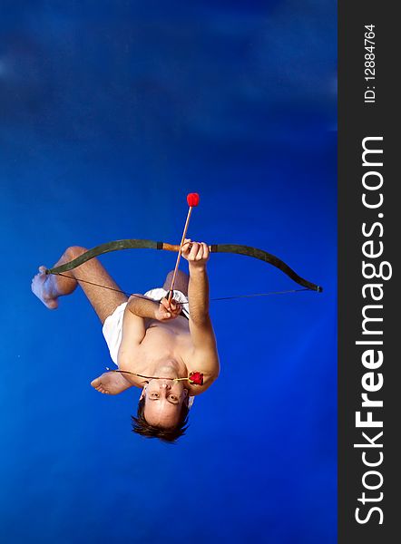 Cupid with bow flying on blue background. Cupid with bow flying on blue background