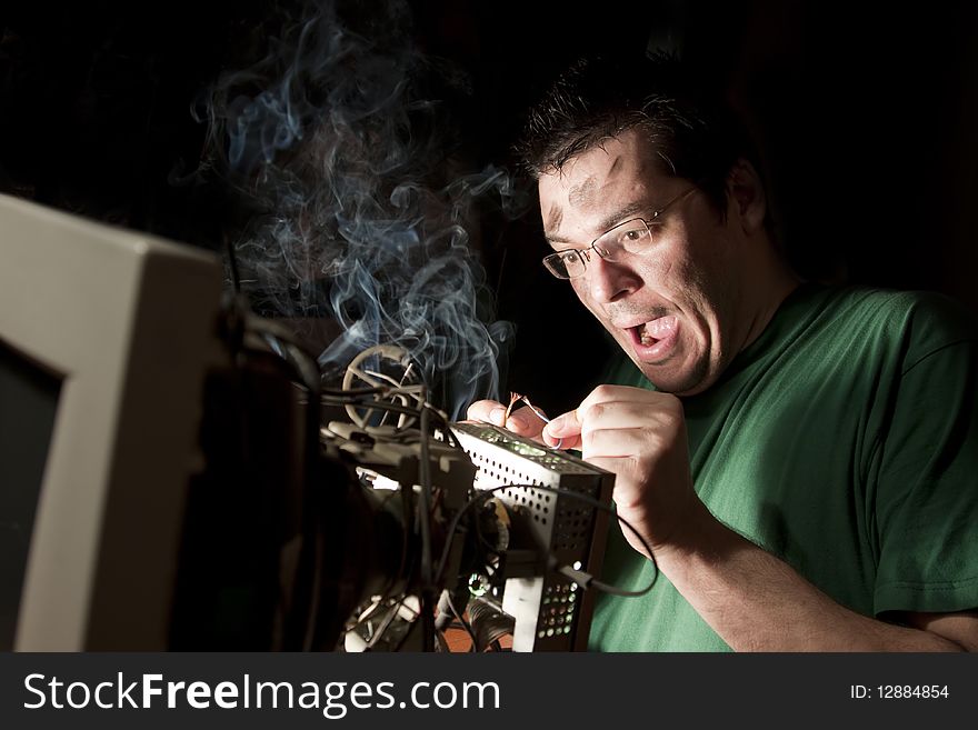 Man repairing old computer on fire