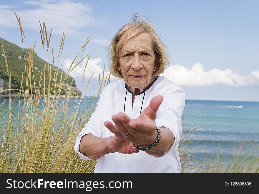 A senior woman practicing Tai Chi by the coast