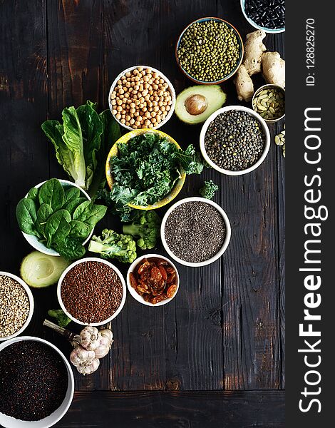 Set raw seeds, cereals, beans, superfoods and green vegetables on dark wooden background top view. vegetarian or diet food concept. Set raw seeds, cereals, beans, superfoods and green vegetables on dark wooden background top view. vegetarian or diet food concept