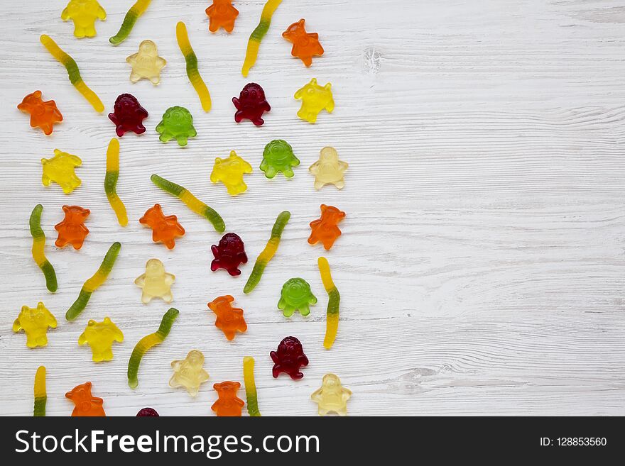 Jelly Monsters And Worms On A White Wooden Background, Top View. From Above, Overhead. Copy Space