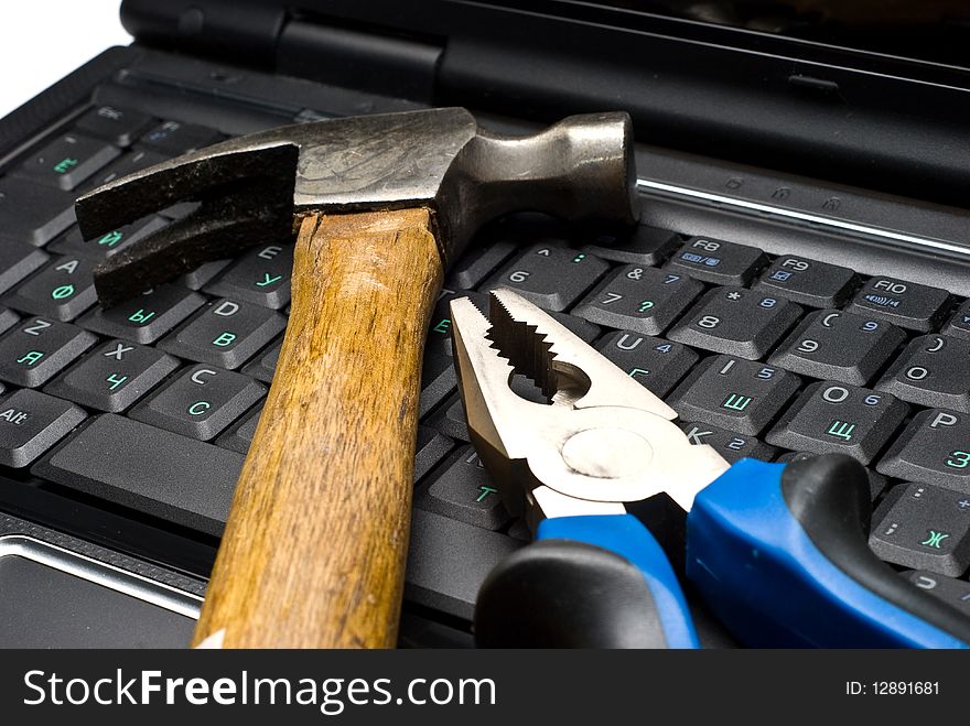 Hammer and pliers on a laptop