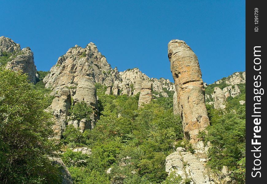 Stony figure and bushes in mountains