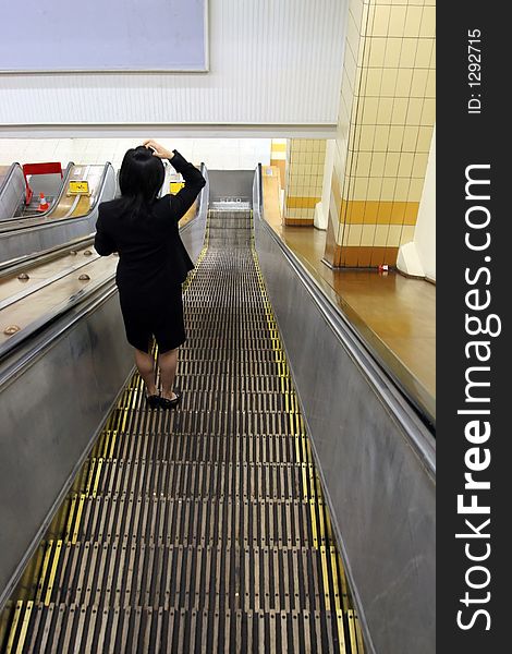 Woman in escalator at subway station