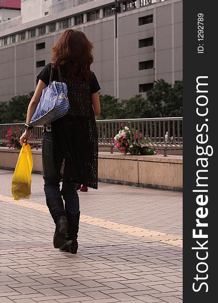 Woman walking a a shopping area of a city. Browse my Shopping collection.