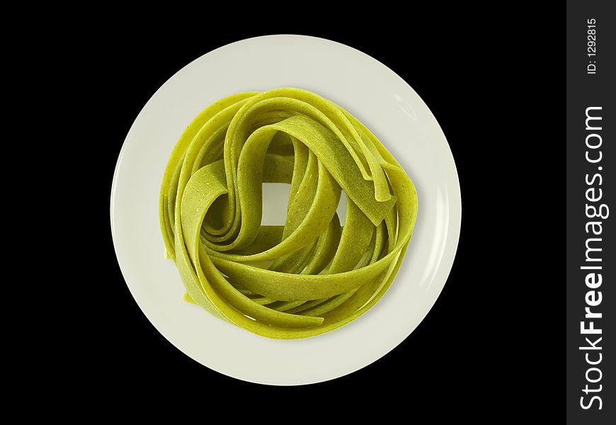 Green noodles on a plate - isolated on black.