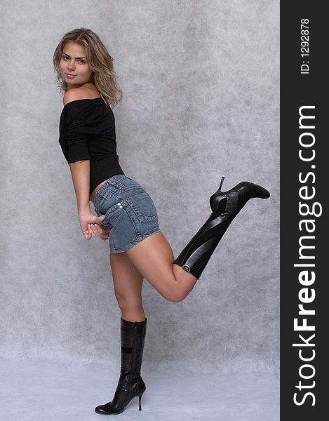 Pretty girl wears jeans skirt and black boot