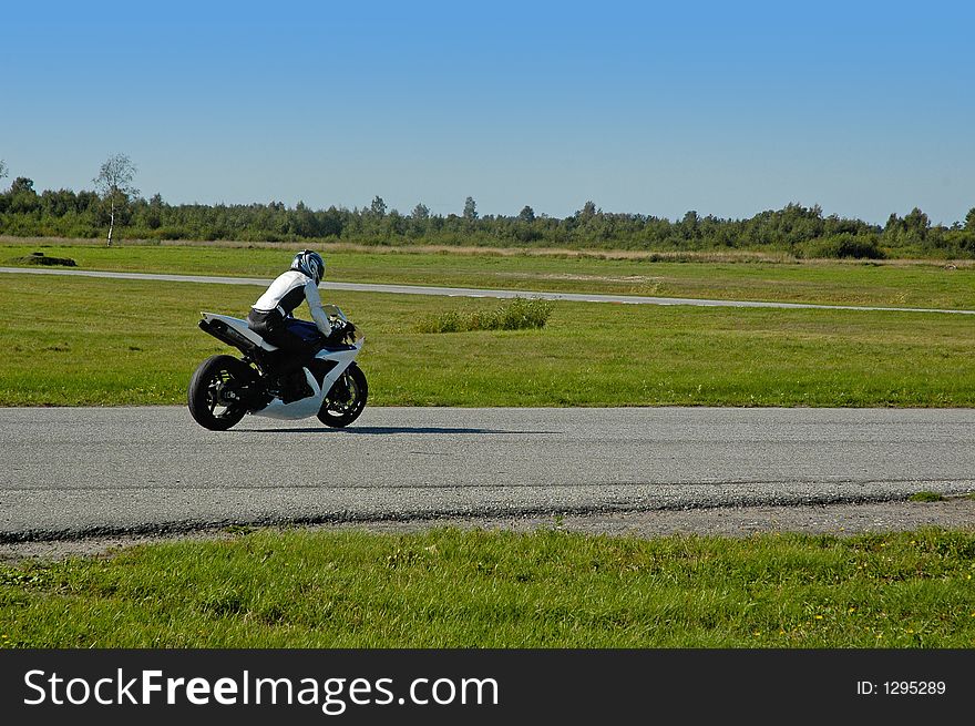 Riding a bike at a sunny track day on an empty race track.