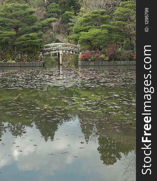 Reflections Of A Japanese Garden And A Stone Bridge