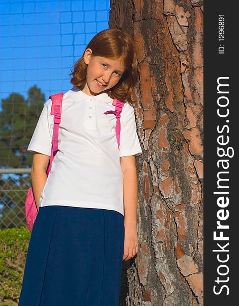 Girl standing by the tree smiling. Girl standing by the tree smiling