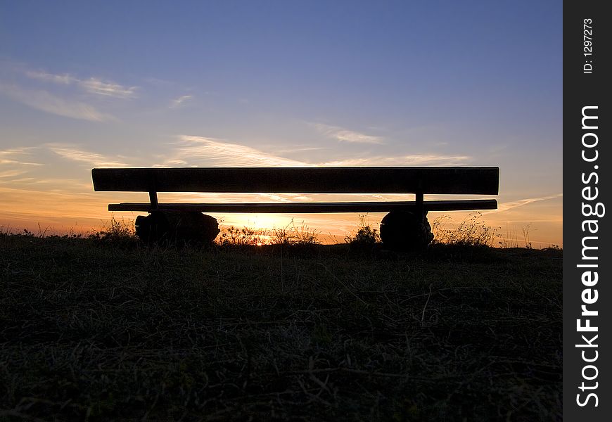 Bench made from logs and setting sun