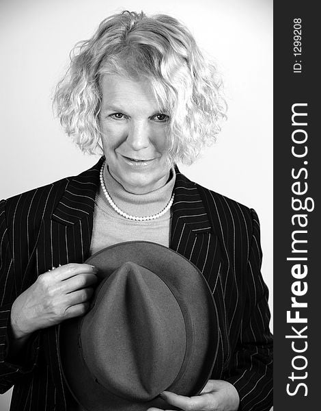 Portrait of an attractive middle-aged woman holding a hat in black & white. Portrait of an attractive middle-aged woman holding a hat in black & white.