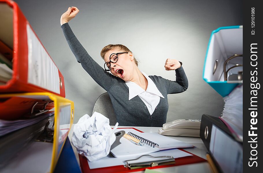 Boredom and fatigue concept. Young emotional expressive woman in office. Bored tired businesswoman yawning stretching at work. Boredom and fatigue concept. Young emotional expressive woman in office. Bored tired businesswoman yawning stretching at work.