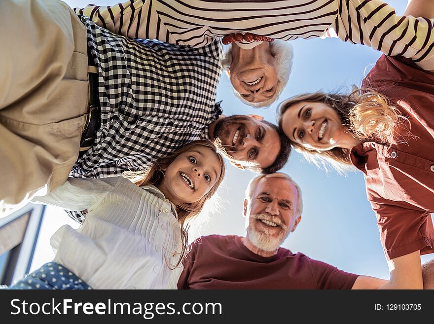 Gather at time. Delighted brunette bearded men keeping smile on his face while looking downwards. Gather at time. Delighted brunette bearded men keeping smile on his face while looking downwards