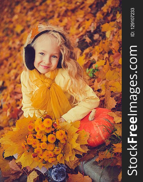 Little beautiful girl with blond hair with big pumpkin in autumn background. Halloween. Little beautiful girl with blond hair with big pumpkin in autumn background. Halloween