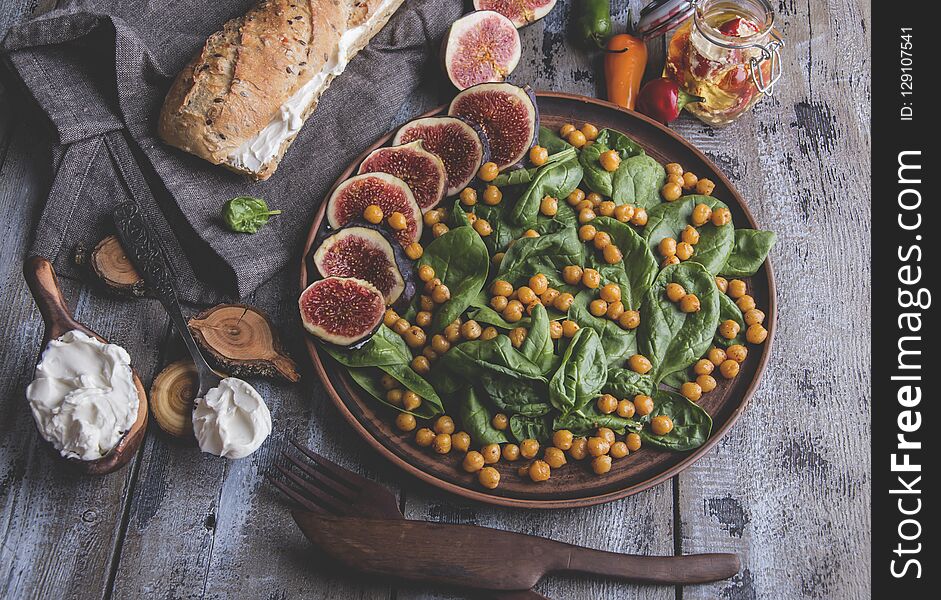 Chickpea, spinach leaves and figs vegetarian salad, cream cheese, healthy homemade vegan food, diet.